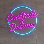 LED-neonskilt i rund form med rosa og blå lys, teksten «Cocktails & Dreams»
