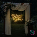 LED-neonskilt med tekst “ALL I want IS you” i gyllent gult lys.