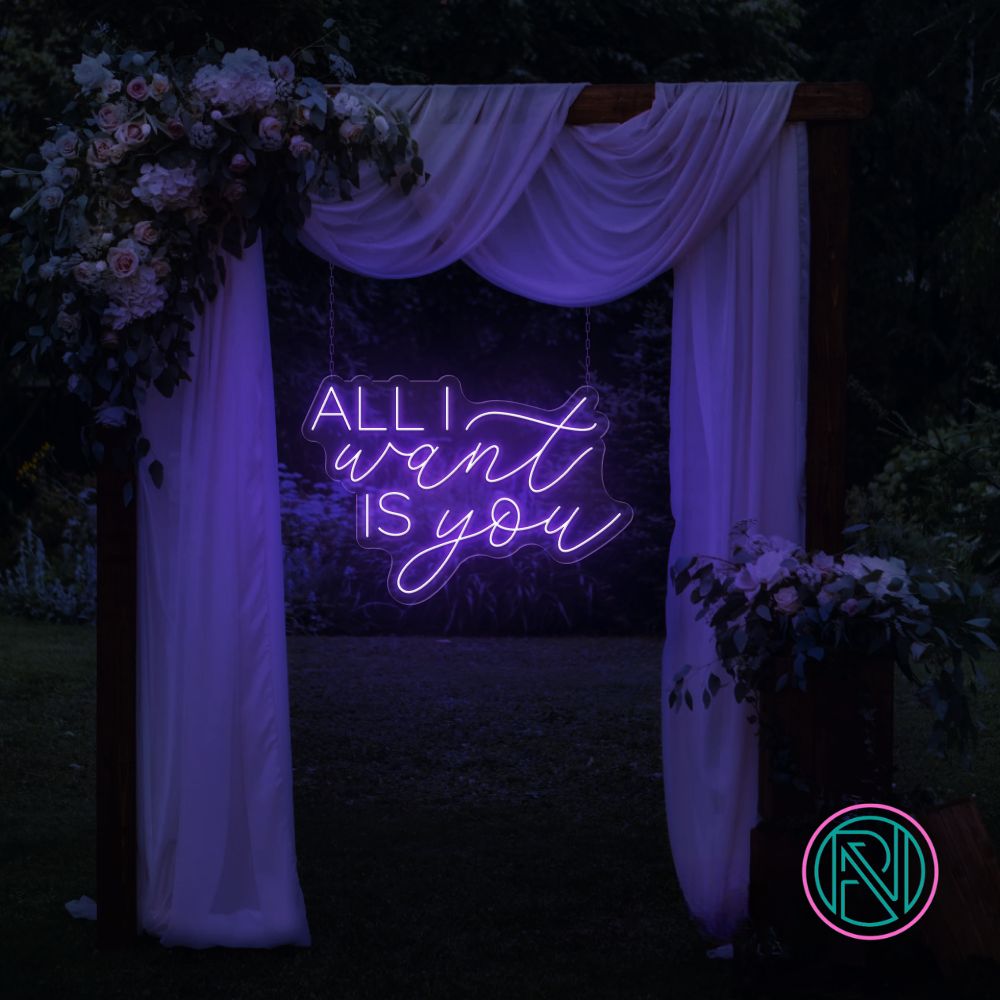 LED-neonskilt med tekst “ALL I want IS you” i fiolblått lys.