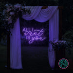 LED-neonskilt med tekst “ALL I want IS you” i fiolblått lys.