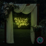 LED-neonskilt med tekst “ALL I want IS you” i sitrongult lys.