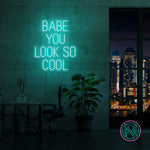LED neonskilt med «BABE YOU LOOK SO COOL», turkis glød.