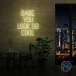 LED-neonskilt med «BABE YOU LOOK SO COOL», gult lys.