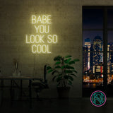LED-neonskilt med «BABE YOU LOOK SO COOL», gult lys.