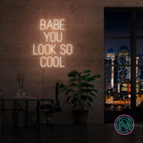 LED-neonskilt med «BABE YOU LOOK SO COOL», oransje lys.