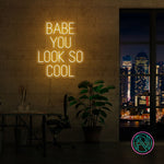 LED-neonskilt med «BABE YOU LOOK SO COOL», gult lys.