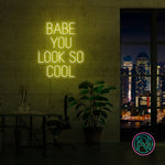LED-neonskilt med «BABE YOU LOOK SO COOL», gult lys.
