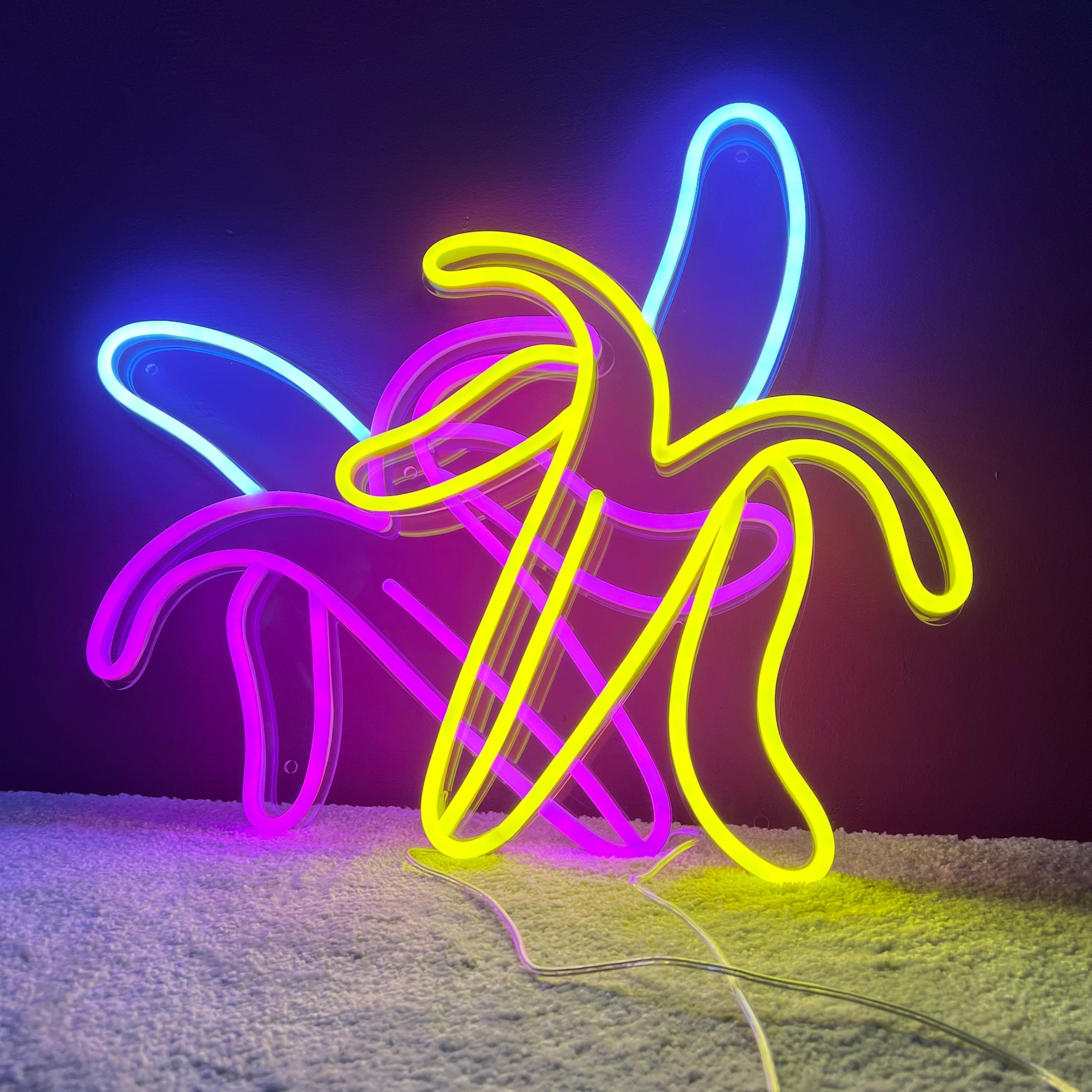LED-neonskilt i bananform i gult, blått og rosa lys.