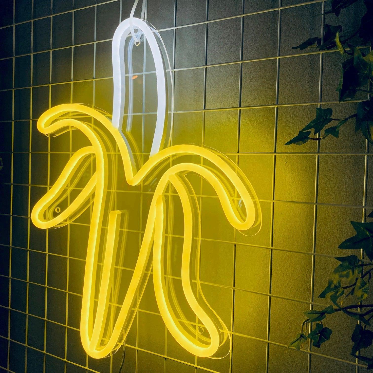 LED-neonskilt i bananform i sitrongult og hvitt lys.