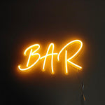 LED neonskilt nærbilde: BAR i gul glød med hvit kontur