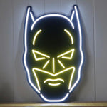 Batman LED neonskilt med hvit kontur og gul markerte øyne, bart og munn.