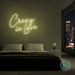 LED neonskilt med teksten «Crazy in Love» i lysgult lys.