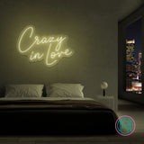 LED neonskilt med teksten «Crazy in Love» i lysgult lys.