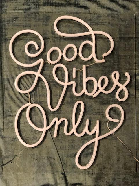 LED neonskilt med tekst «Good Vibes Only» i rosa skrift, firkantet.