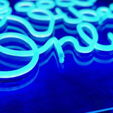 Nærbilde av LED-neonskrift i blått lys på neonskilt.