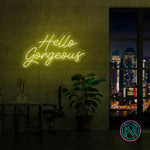 LED neonskilt «Hello Gorgeous» i gult lys på vegg