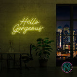 LED neonskilt «Hello Gorgeous» i gult lys på vegg