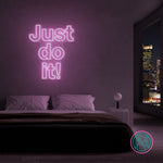 LED-neonskilt med teksten “Just do it!” i lilla/rosa lys.