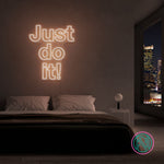 LED-neonskilt i varm/hvit glød på vegg med «Just do it!»