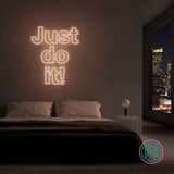 LED-neonskilt i varm/hvit glød på vegg med «Just do it!»