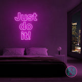 LED-neonskilt med teksten “Just do it!” i rosa/lilla lys.