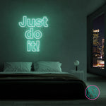 LED-neonskilt med teksten “Just do it!” i lys turkisgrønt lys.