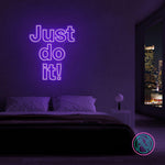 LED-neonskilt med teksten “Just do it!” i fiolett/blått lys.