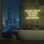 Neonskilt med tekst «Please don’t do coke in the bathroom» i gul glød