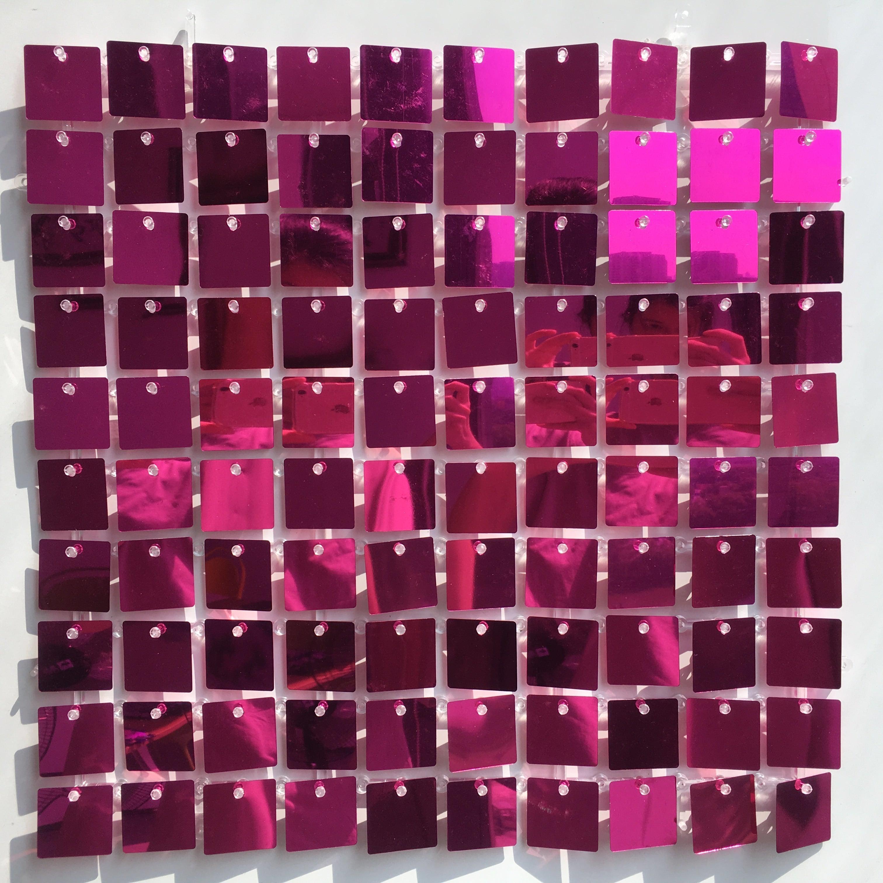 Glitrende veggdekor med rosa og magenta firkantede paljetter på opphengslister