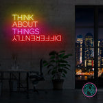 LED neonskilt med fargerik tekst «THINK ABOUT THINGS», oppslått på vegg.