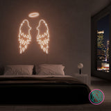 LED neonskilt med vingemotiv i hvitt lys.