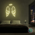LED neonskilt med vingemotiv i gult lys.