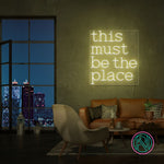 LED-neonskilt med teksten "this must be the place" i kjølig hvit glød.